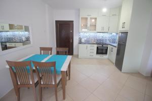 eine Küche und ein Esszimmer mit einem Tisch und Stühlen in der Unterkunft Kosta's Apartment in Sarandë