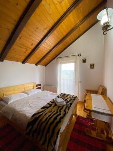 un letto zebrato in una stanza con finestra di La Cabana a Băile Borşa