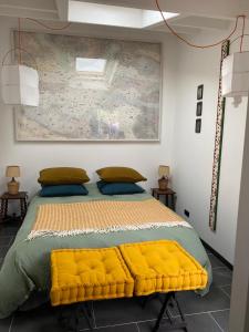 a bedroom with a large bed with a yellow blanket at Le Jardin de Fileraise Pour un couple in Le Bois-Plage-en-Ré