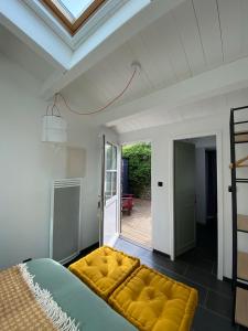 a bedroom with a large yellow bed in a room at Le Jardin de Fileraise Pour un couple in Le Bois-Plage-en-Ré