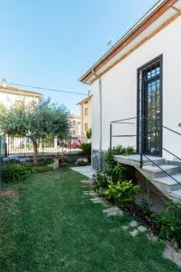 uma casa com um jardim relvado ao lado de um edifício em Villetta Belvedere em Piacenza