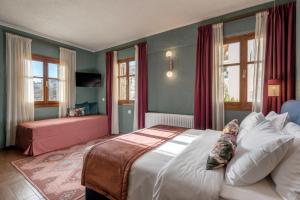 sypialnia z dużym łóżkiem i różową kanapą w obiekcie Paeonia Arachova w mieście Arachova