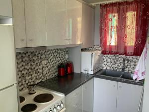 uma cozinha com armários brancos e um forno com placa de fogão em Xenia Apartment em Kokkari