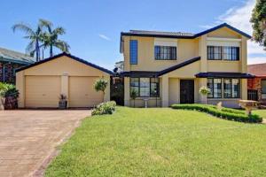 een huis met een garage en een grasveld bij Horsley Retreat in Dapto