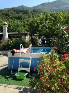 una persona tumbada en una silla en una piscina en B&B Lodge dell'Ospite Ischia en Ischia