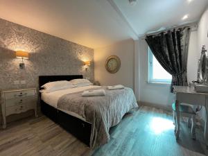 - une chambre avec un lit et 2 serviettes dans l'établissement Apartments No. 19, à Portpatrick