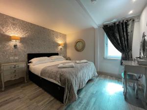 a bedroom with a bed with two towels on it at Apartments No. 19 in Portpatrick