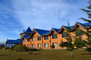 a large wooden house with a blue roof at Los Ñires Ushuaia in Ushuaia