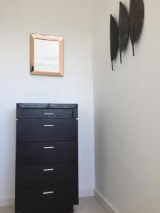 a black dresser with a mirror on a wall at Sky View Apartment with Terrace in Bedford