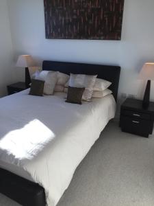 a large bed with white sheets and pillows at Sky View Apartment with Terrace in Bedford