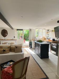 a living room with a couch and a kitchen at Le Jardin de Fileraise Pour un couple in Le Bois-Plage-en-Ré