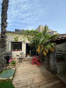 a wooden deck in front of a house at Le Jardin de Fileraise Pour un couple in Le Bois-Plage-en-Ré