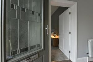 a glass door to a room with a hallway at 3-Bedroom Luxury Home in Horbury
