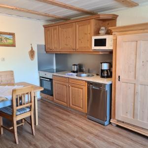 eine kleine Küche mit Holzschränken und einem Tisch in der Unterkunft Haus Cornelia in Jungholz
