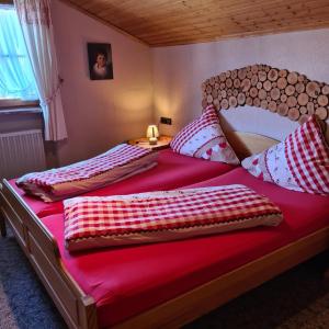 1 Schlafzimmer mit 2 Betten und roter Bettwäsche in der Unterkunft Haus Cornelia in Jungholz