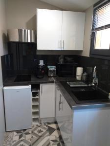 a kitchen with white cabinets and a black counter top at Pigeonnier in Vic-le-Comte