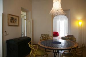 タヴィラにあるTavira Homeのテーブルと椅子、シャンデリアが備わる客室です。