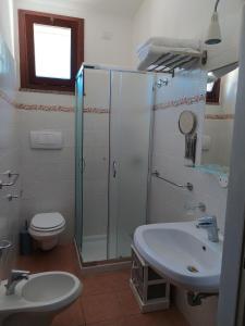 Un baño con ducha, lavabo e inodoro. en Guesthouse Pintadera, en Santa Maria la Palma