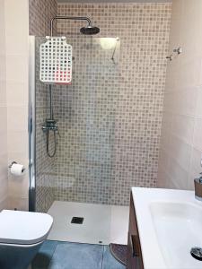 y baño con ducha, aseo y lavamanos. en Apartamento VISTAenRELAX, en Puerto del Carmen