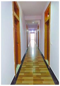 an empty hallway with a long hallway with wooden floors at AYM Yoga Resort Arambol GOA in Arambol