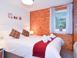 a bedroom with two beds and a window at Ben Rinnes Lodge Glenlivet Highlands in Auchnastank