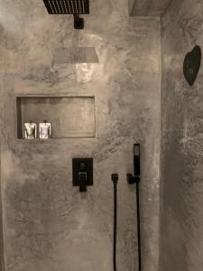 a bathroom with a wall with a shower and two toilets at Refúgio da Falésia in Sesimbra