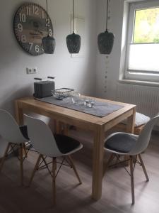 a wooden table with chairs and a clock on the wall at bei Valters in Kreuzau +12 photos