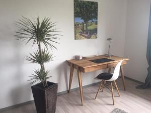 a wooden desk with a chair and a potted plant at bei Valters in Kreuzau