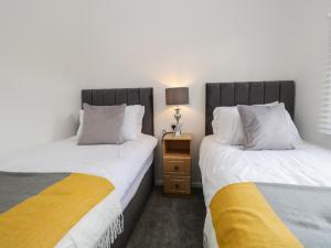 two beds sitting next to each other in a room at Grizedale Lodge in Windermere