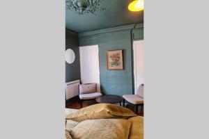 - une chambre avec un lit et une chaise dans l'établissement Grand Studio de charme Rouen centre, à Rouen