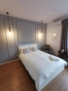 una camera da letto con un grande letto bianco con due cuscini di On the river Ultra central Suites a Bucarest