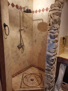 a bathroom with a shower with a stone floor at Domaine des Maillets in Blot-lʼÉglise
