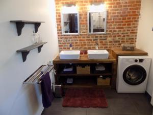 a bathroom with two sinks and a washing machine at Gîte des Marmouzeaux in Lemé