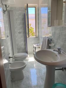 uma casa de banho com 2 WC e um lavatório em Petit gourmet em Siderno Marina