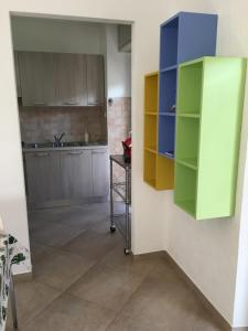 cocina con armarios coloridos y lavabo en una habitación en Appartamento Vittoria, en Aosta