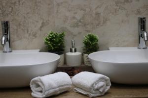 two white sinks in a bathroom with towels at Hotel Regina Margherita in Bordighera