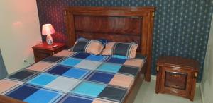 a bedroom with a bed with a wooden head board at Appartement meublé à MBAO in Mbaw Gou Ndaw