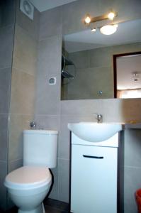 Łazienka z białą toaletą i umywalką w obiekcie Słoneczne Tarasy w mieście Mikołajki