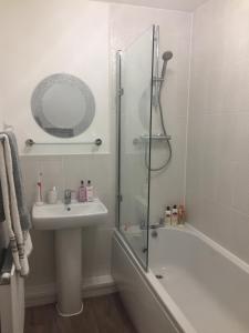 ein Badezimmer mit einer Dusche, einem Waschbecken und einer Badewanne in der Unterkunft The Serlio Baroque Court Apartment in Newport