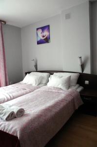 1 dormitorio con 1 cama con 2 toallas en Słoneczne Tarasy, en Mikołajki