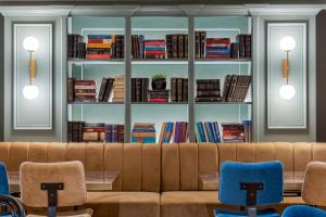 a living room with a couch and shelves of books at Paeonia Arachova in Arachova