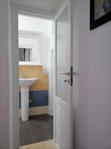 a bathroom with a sink and a glass door at Bed and Breakfast Villa Angelina in Lipari