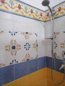eine Dusche in einem Badezimmer mit bunten Fliesen in der Unterkunft Casa Vacanze "Villa Angelina" in Lipari + 39 Fotos