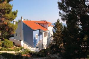 a white house with an orange roof at Apartments Maja in Hvar