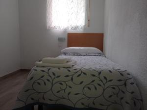 Pension Cuatro Torres في مدريد: غرفة نوم عليها سرير وفوط