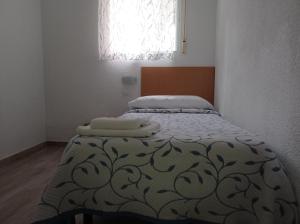1 dormitorio con 1 cama con 2 toallas en Pension Cuatro Torres en Madrid