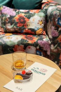 un tavolo in legno con un bicchiere di whisky e un drink sopra di Paeonia Arachova ad Aráchova