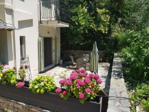 a garden with pink flowers and a balcony at Menehuna Heartmade Maison in Chorefto