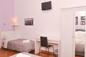- une chambre avec un bureau, un lit et un miroir dans l'établissement Colazione Al Vaticano Guest House, à Rome