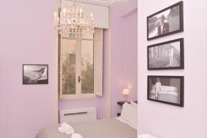 a bedroom with a chandelier and pictures on the wall at Colazione Al Vaticano Guest House in Rome